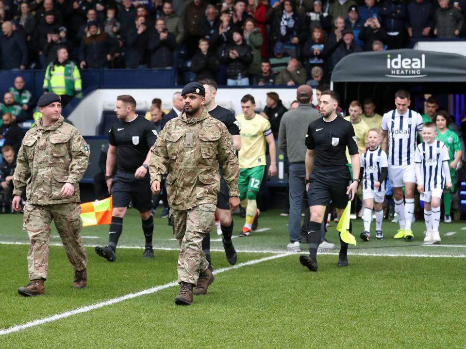 Albion and Bristol City are led out onto the pitch by members of the military 