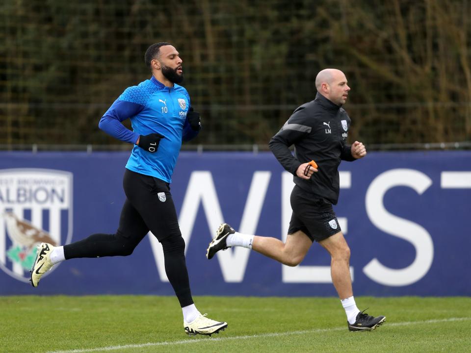 Matty Phillips running with a fitness coach during a training session