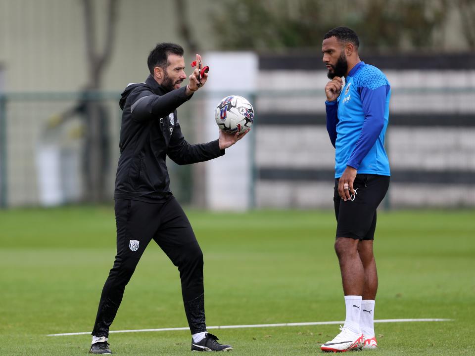 Carlos Corberán speaking to Matty Phillips out on the training pitch 