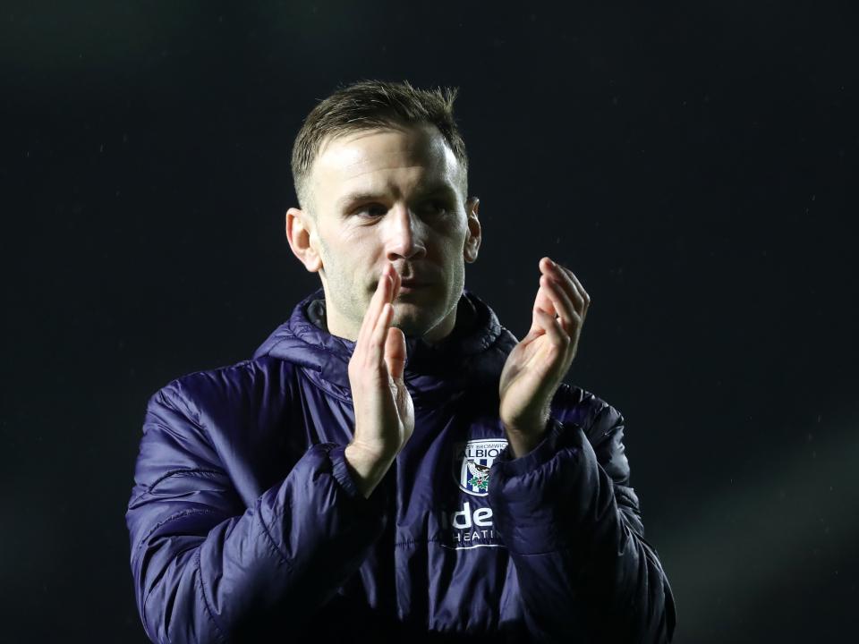 Andi Weimann applauding Albion fans while wearing a big blue Baggies coat