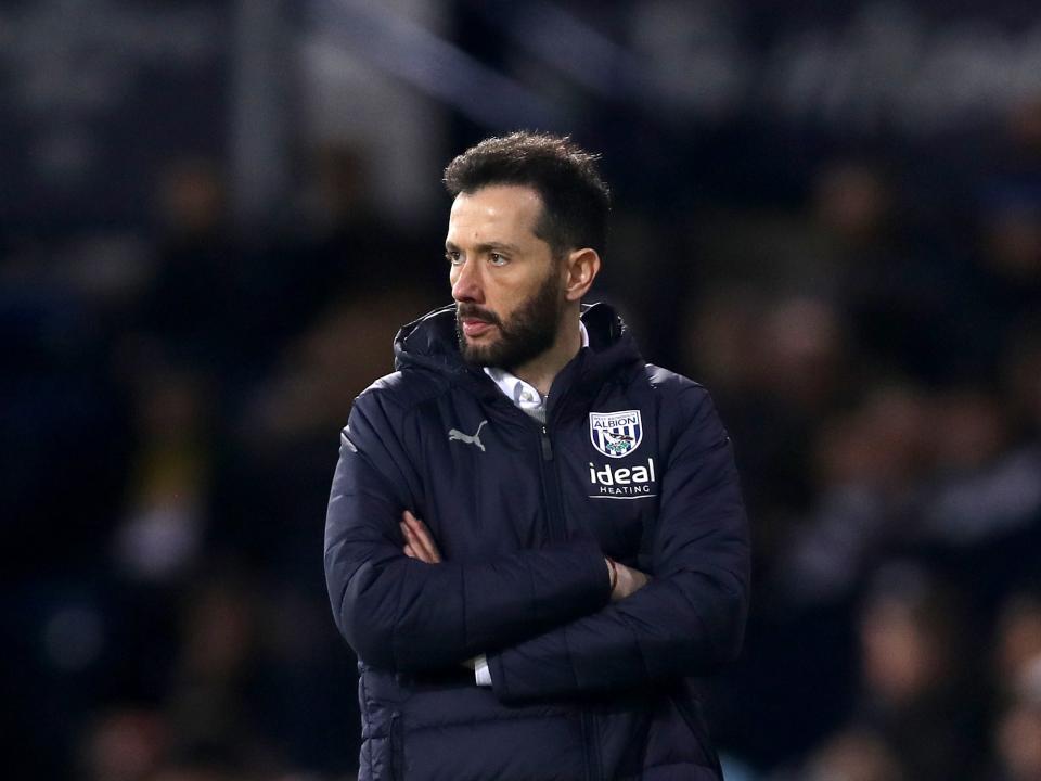 Carlos Corberán stood with his arms crossed on the side of the pitch at The Hawthorns during an Albion game