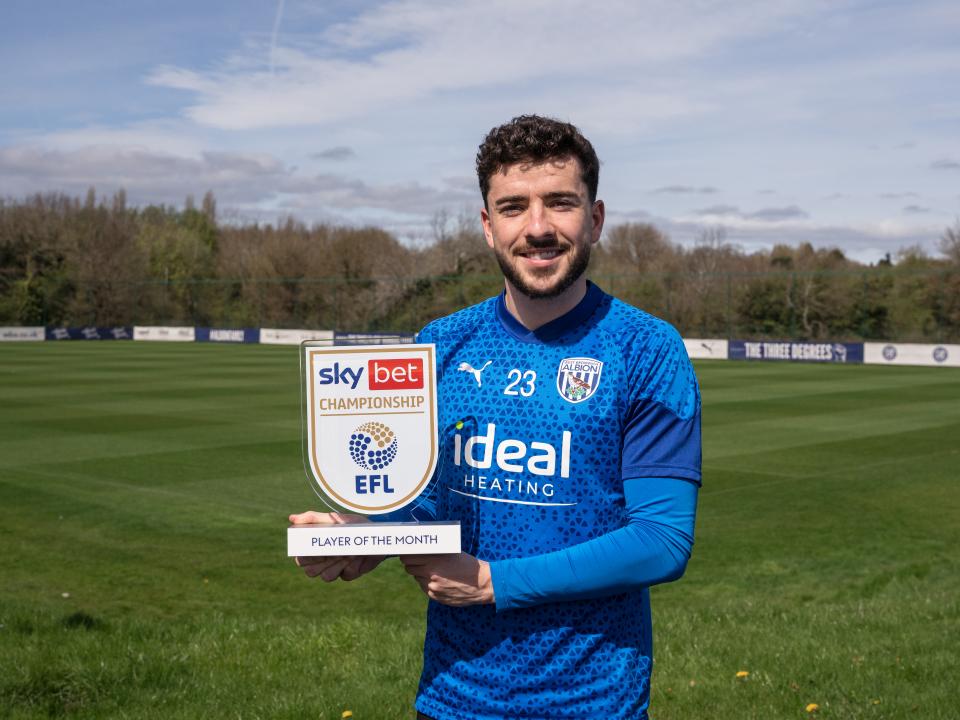 Mikey Johnston holding his Player of the Month trophy while wearing Albion training kit
