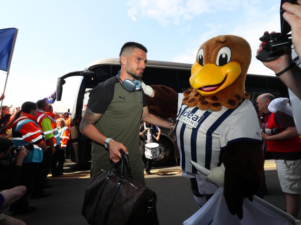 Okay Yokuslu is greeted by Baggie Bird upon arrival at The Hawthorns before Albion's game with Southampton 