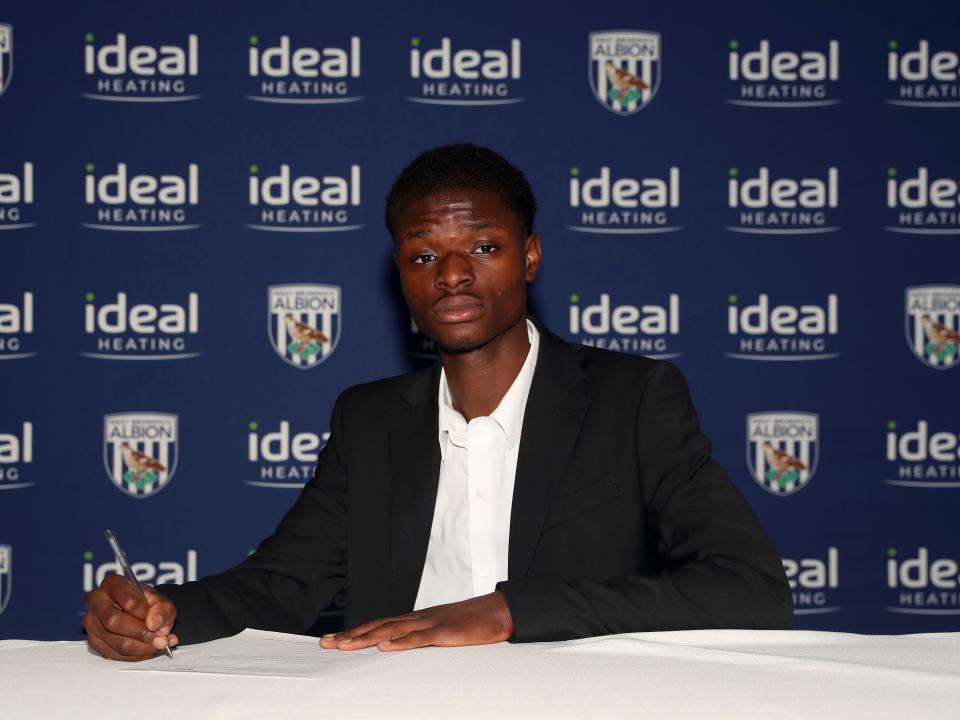 A photo of Abdul Abudu signing his scholarship deal