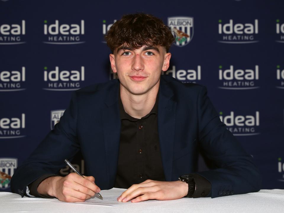 A photo of Alfie Maughan signing his scholarship deal