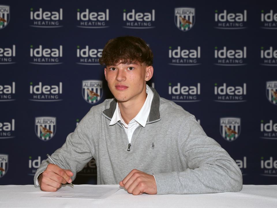 A photo of Noah DuPont signing his scholarship deal