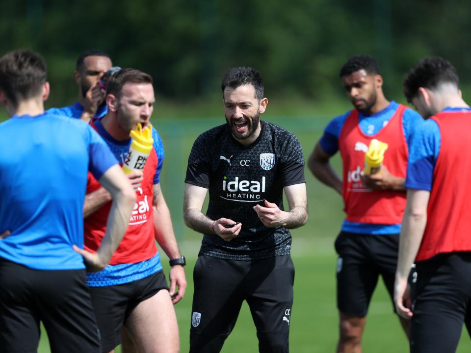 Carlos Corberán delivering a message to his players on the training pitch 