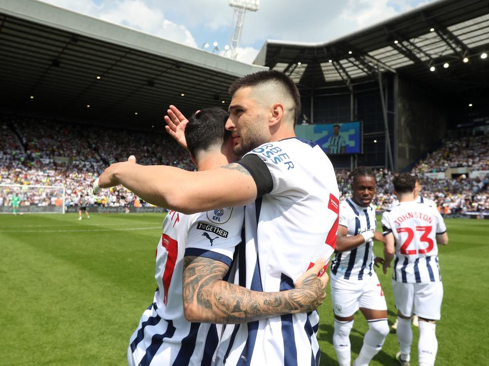 Okay Yokuslu hugs Alex Mowatt on the pitch at The Hawthorns before the game against Southampton 