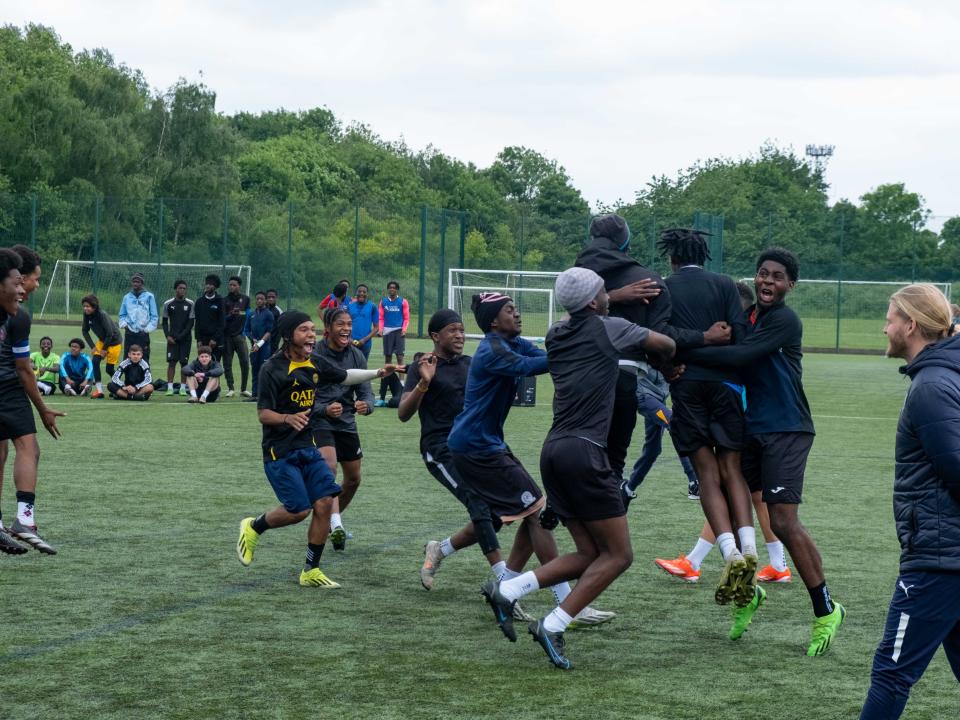 Team (Non bibs) jumping for joy, celebrating a penalty shoot out win.