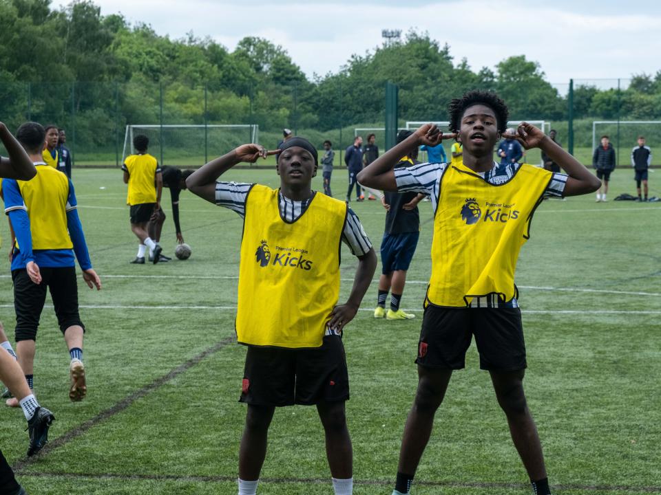 Two yellow bib players, doing the "Rashford" celly.