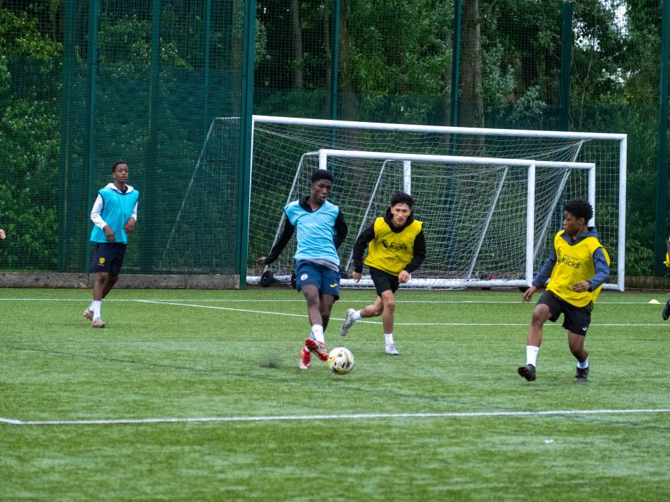 Aqua blue team in possession of the ball, yellow bibs chasing.