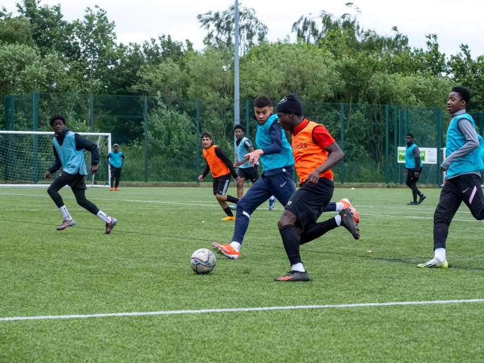 Aqua Blue v Orange, players chasing the ball.