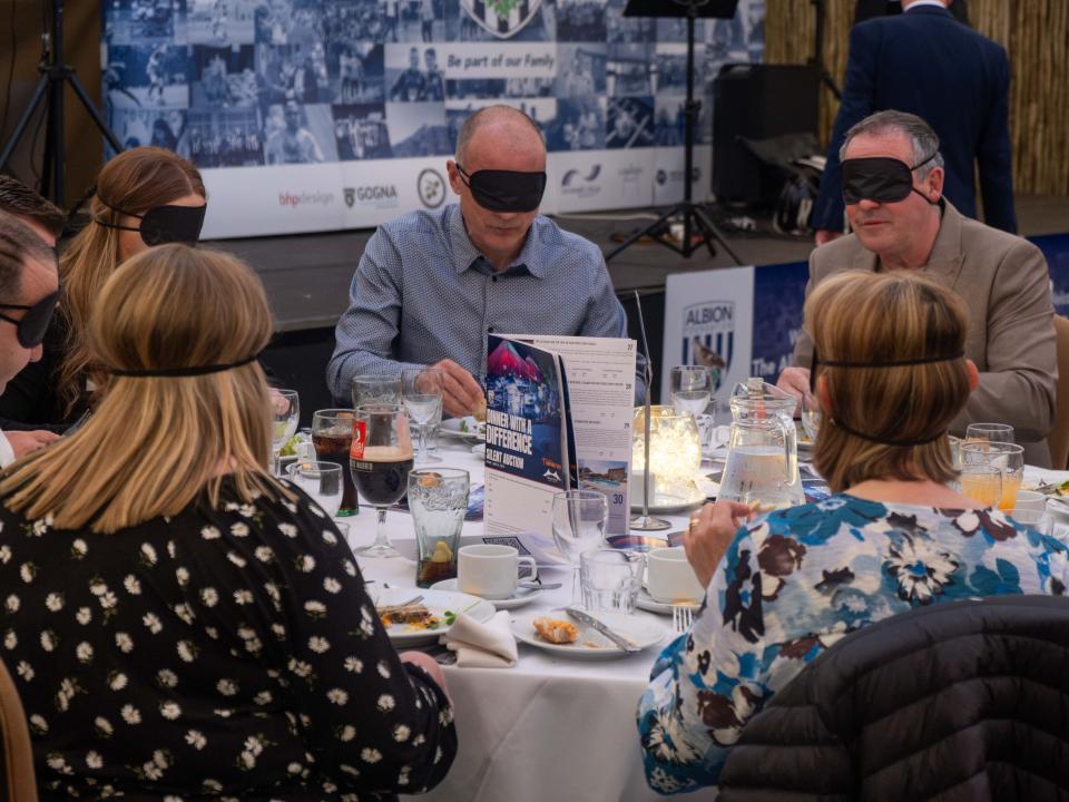 Diners seated at a table blindfolded.