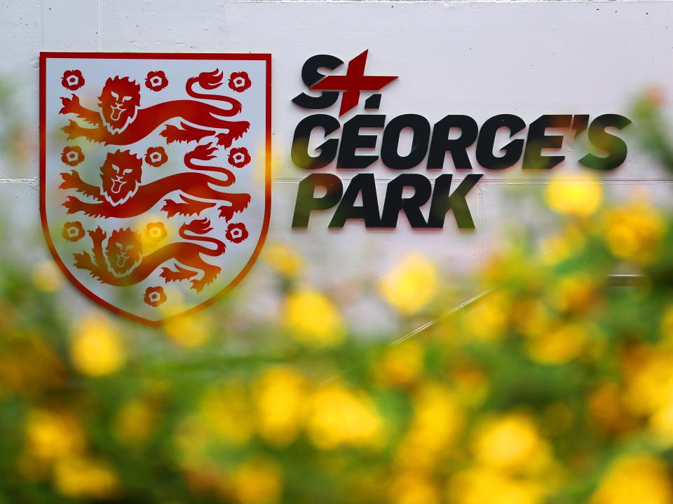 Branding on the wall at St. George's Park with flowers in front 
