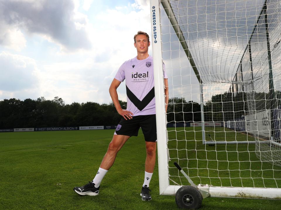 Torbjørn Heggem leaning on a goal post smiling at the camera 