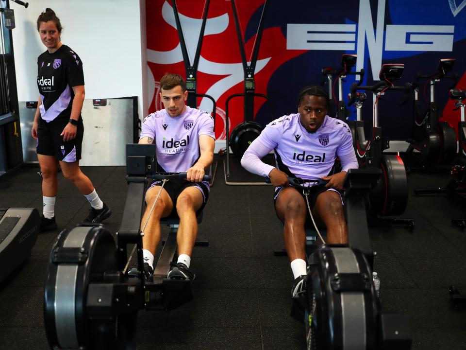Jayson Molumby and Reyes Cleary on the rowing machine in the gym at St. George's Park