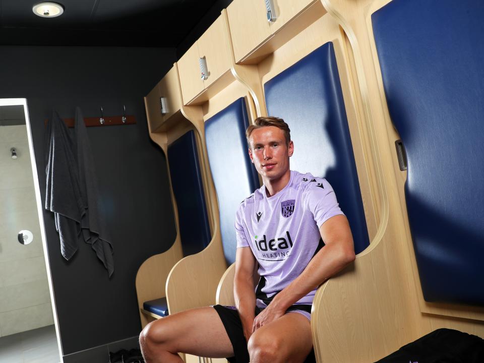 Torbjørn Heggem smiling at the camera while sat inside a dressing room 
