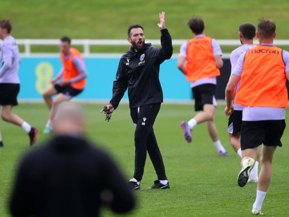 Carlos Corberán out on the training pitch at St. George's Park surrounded by players
