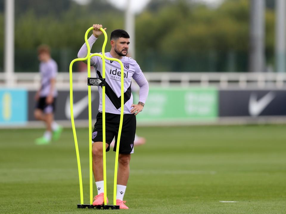 Alex Mowatt stood by a mannequin on the training pitch at St. George's Park