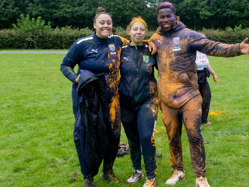 Three Foundation staff members, arm in arm, posing for photo.