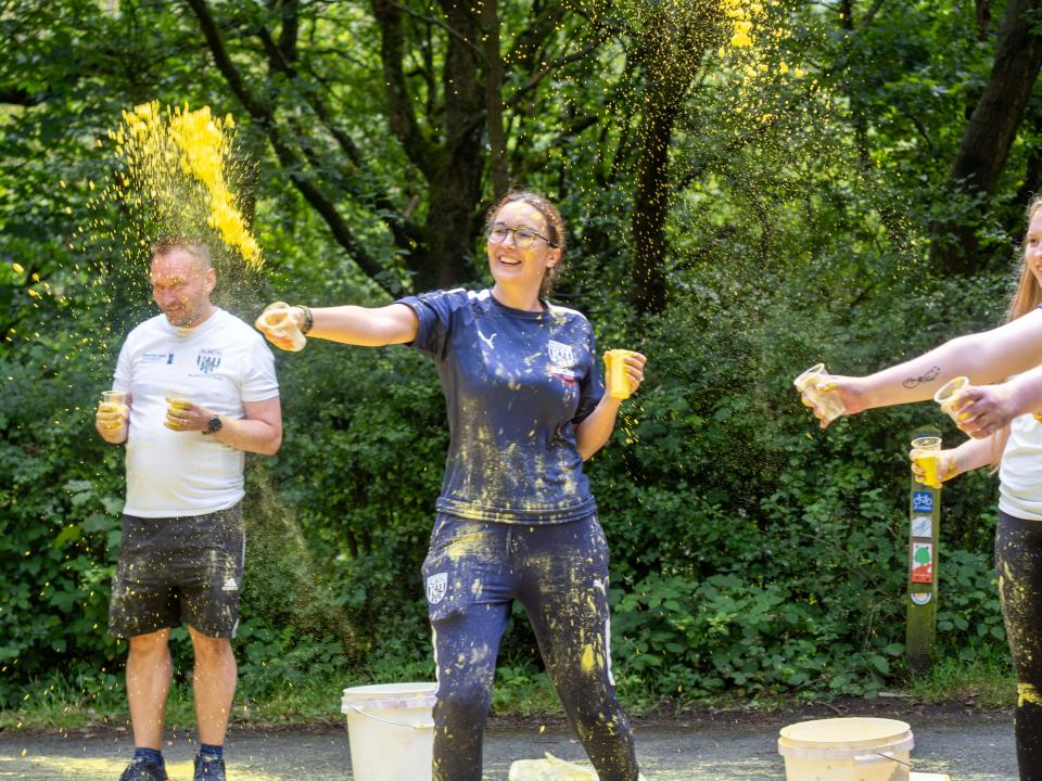 Foundation staff and volunteers at the colour station, throwing paint powder.