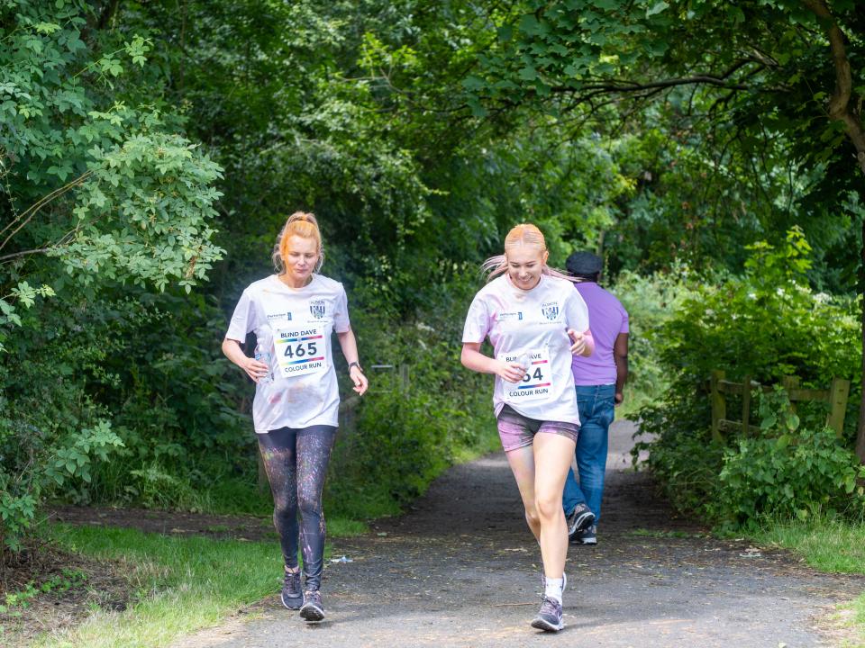 Two runners heading along the path, surround by trees