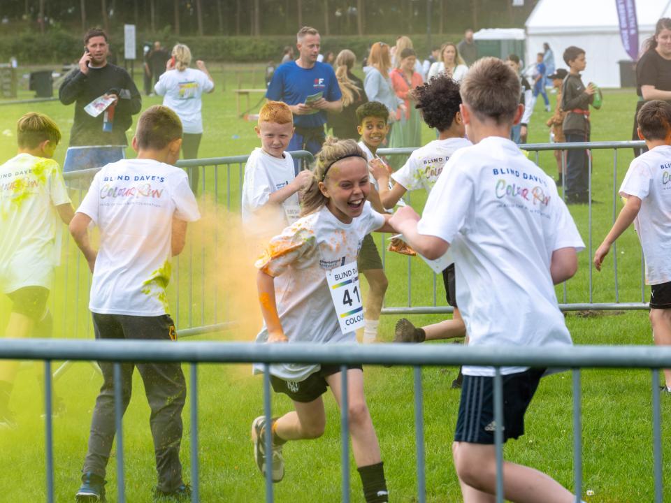 MJPL teammates throwing yellow paint powder.