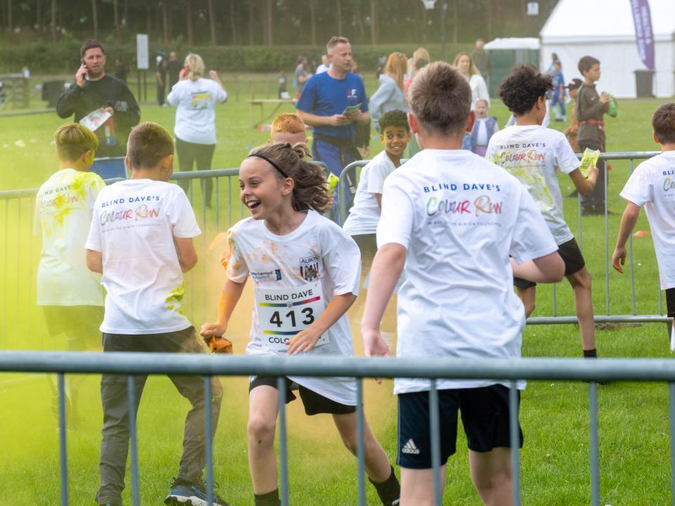 MJPL teammates throwing yellow paint powder.