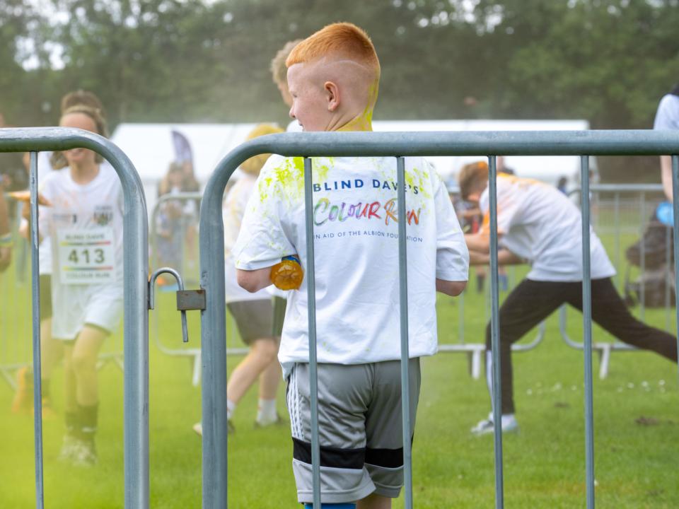 Participant displaying Blind Dave Colour Run branding on the back of t-shirt.