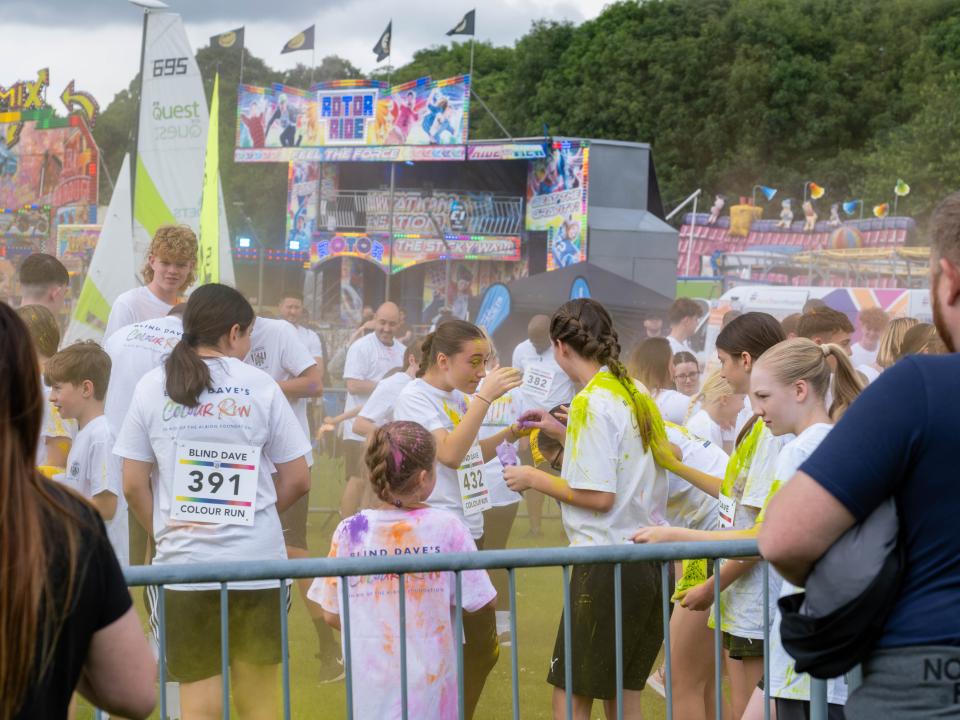 Group of participants inside barrier throwing paint powder.