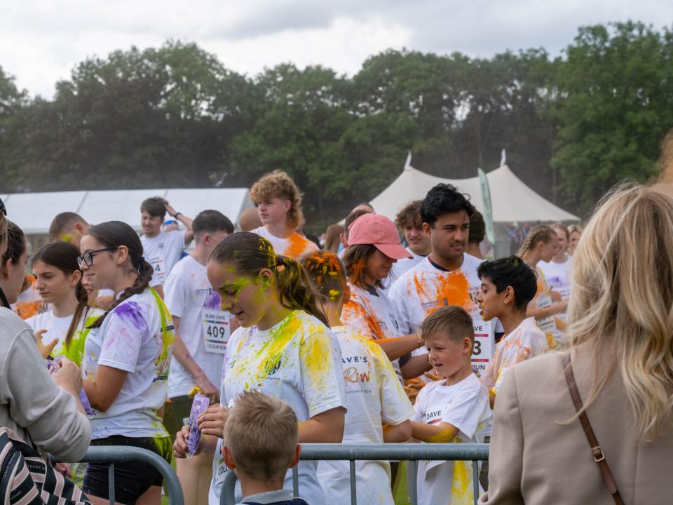 Group of participants inside barrier throwing paint powder.