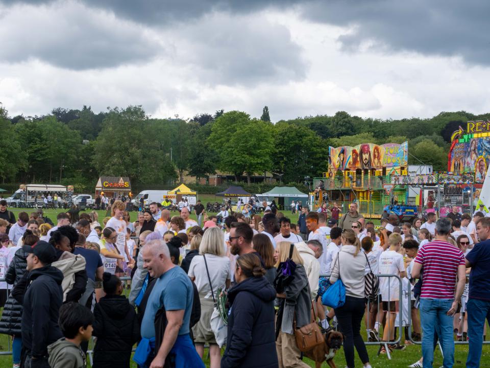 Wide shot of participants inside barrier throwing paint powder.