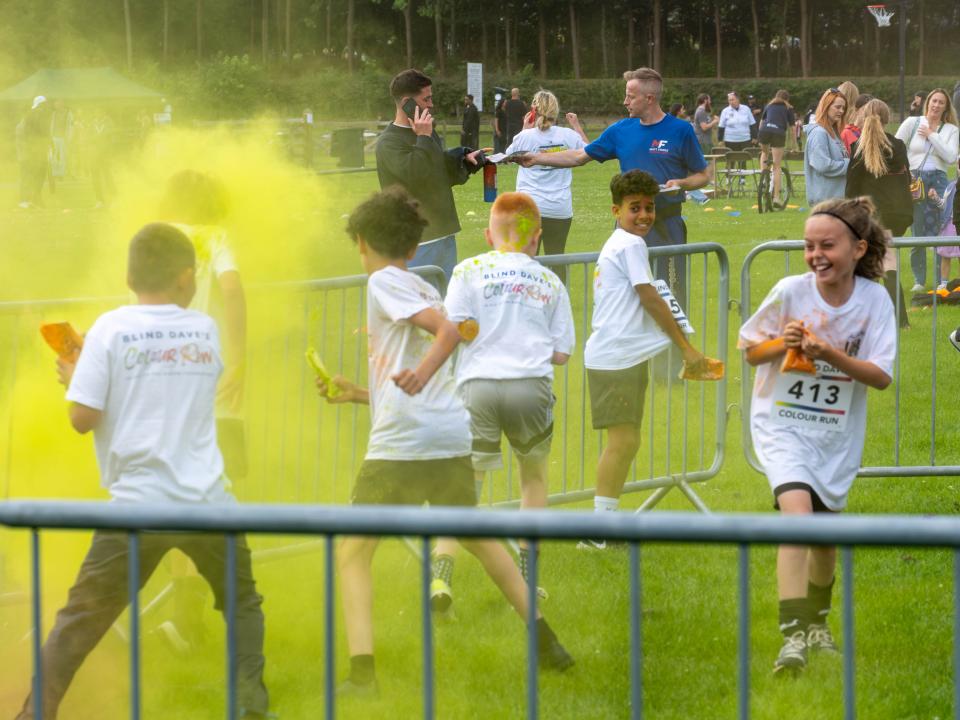 MJPL teammates throwing yellow paint powder.