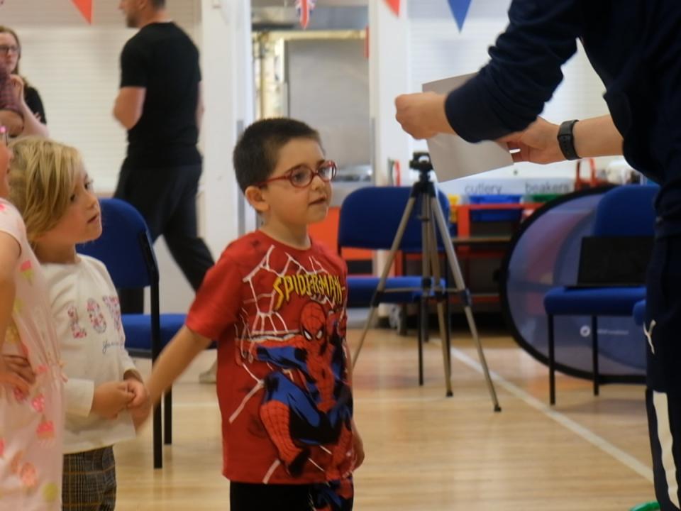 Abel reads a phonic sound from a card as Greg Warren holds it up.