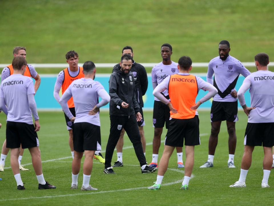 Carlos Corberán speaking to a large group of Albion players out on the pitch at St. George's Park
