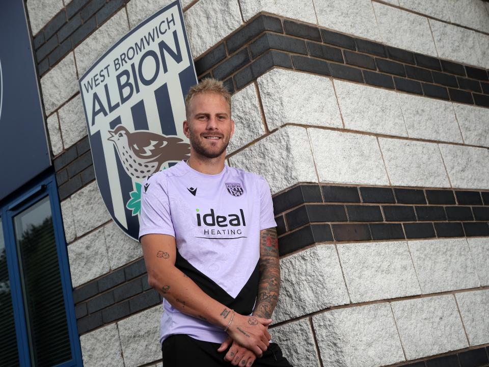 Uroš Račić smiling at the camera while stood outside the front of the training ground 
