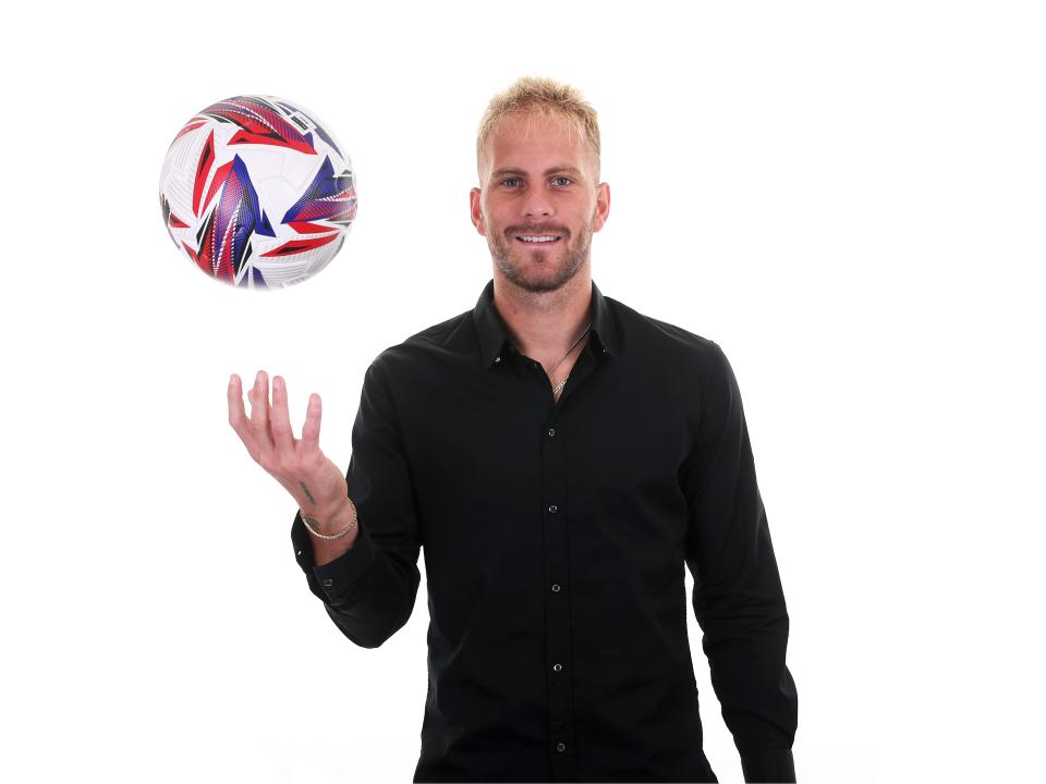 Uroš Račić smiling at the camera while juggling a ball 