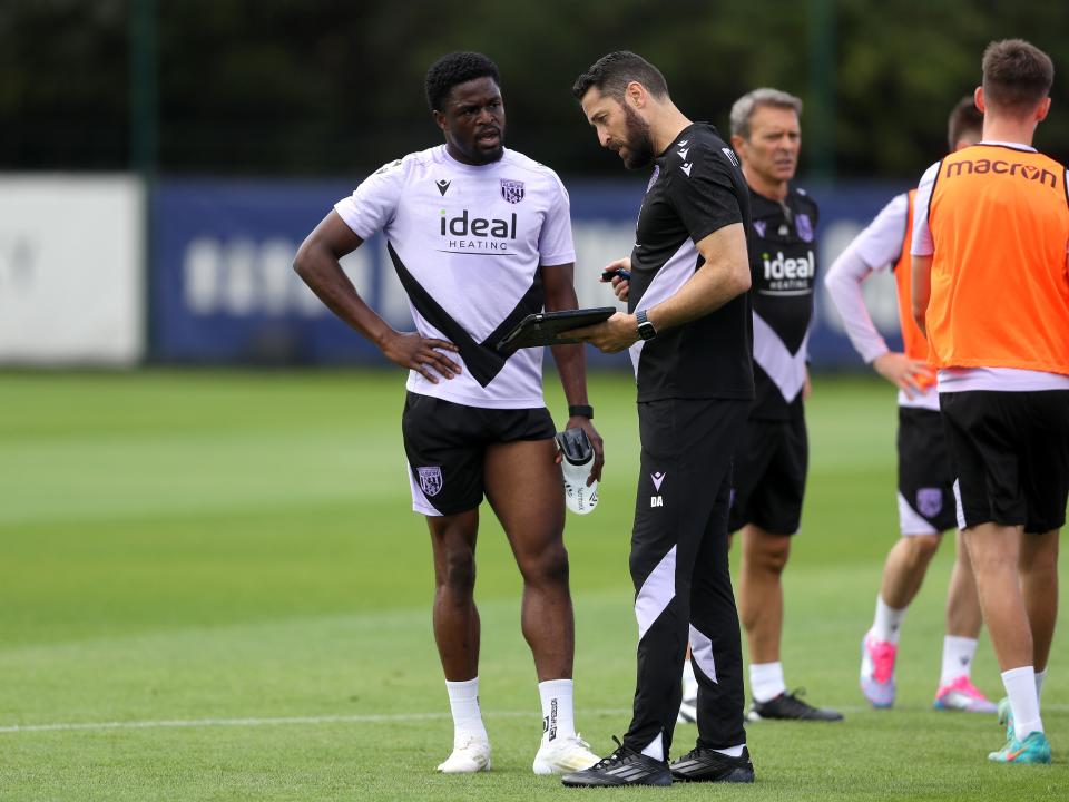 Josh Maja receiving instructions from coach Damia Abella on the training pitch 