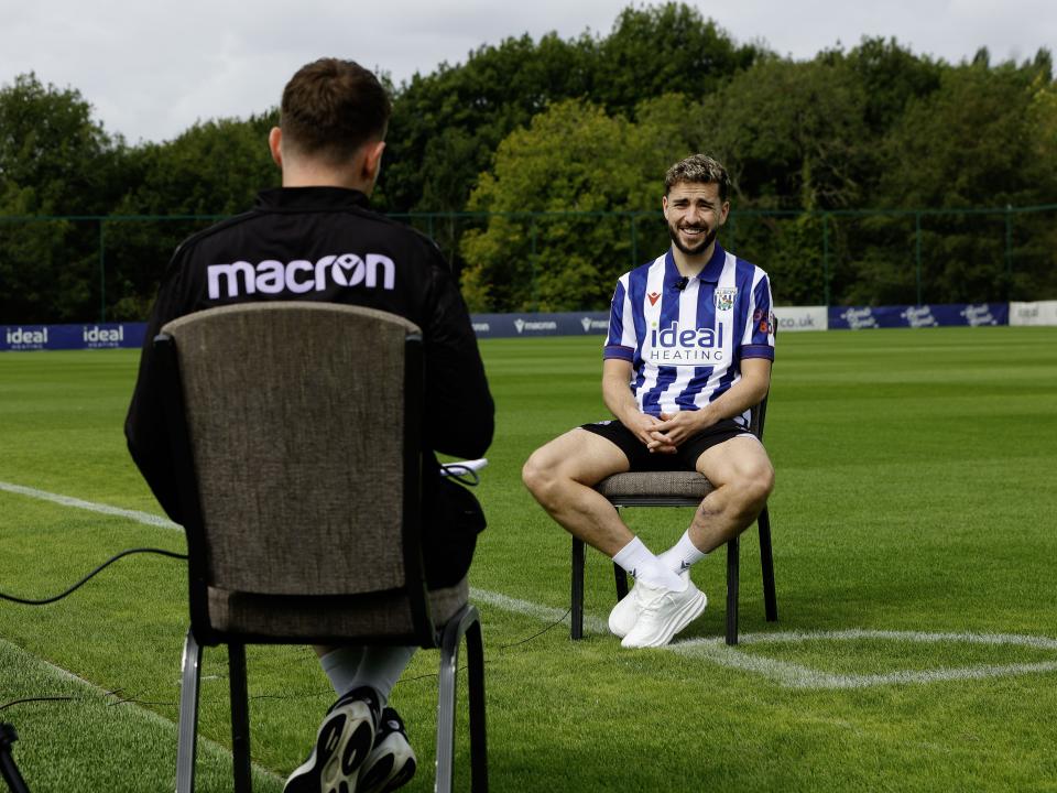 Mikey Johnston sat in a chair on the training pitch being interviewed 