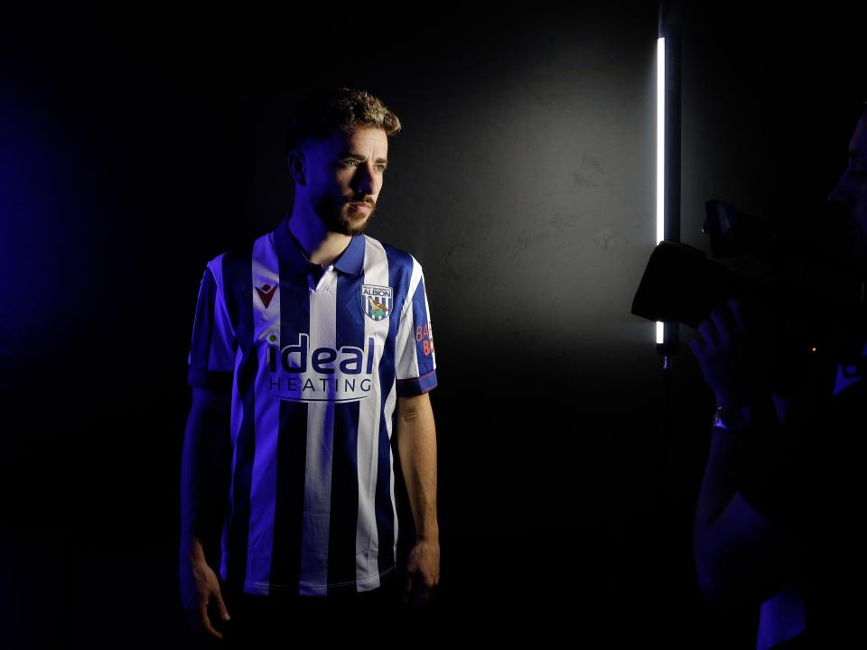 Mikey Johnston stood in a TV studio in a home shirt 
