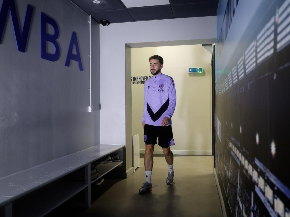Mikey Johnston walking through a corridor at the training ground 