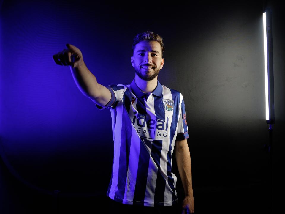 Mikey Johnston pointing at the camera while wearing a home shirt and stood in a TV studio 