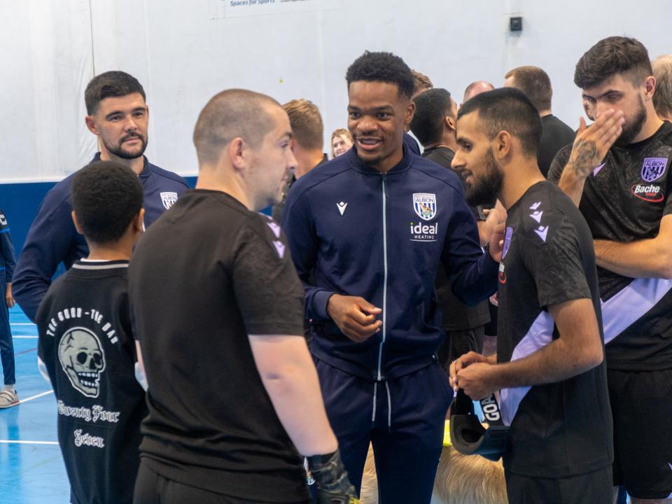 Albion first team players receive a blind football explanation.