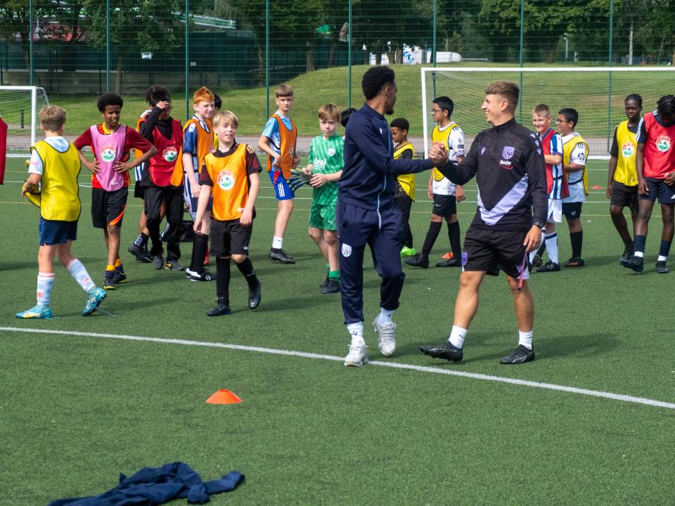 Grady Diangana shakes hands with Foundation coach Rhys Warner.
