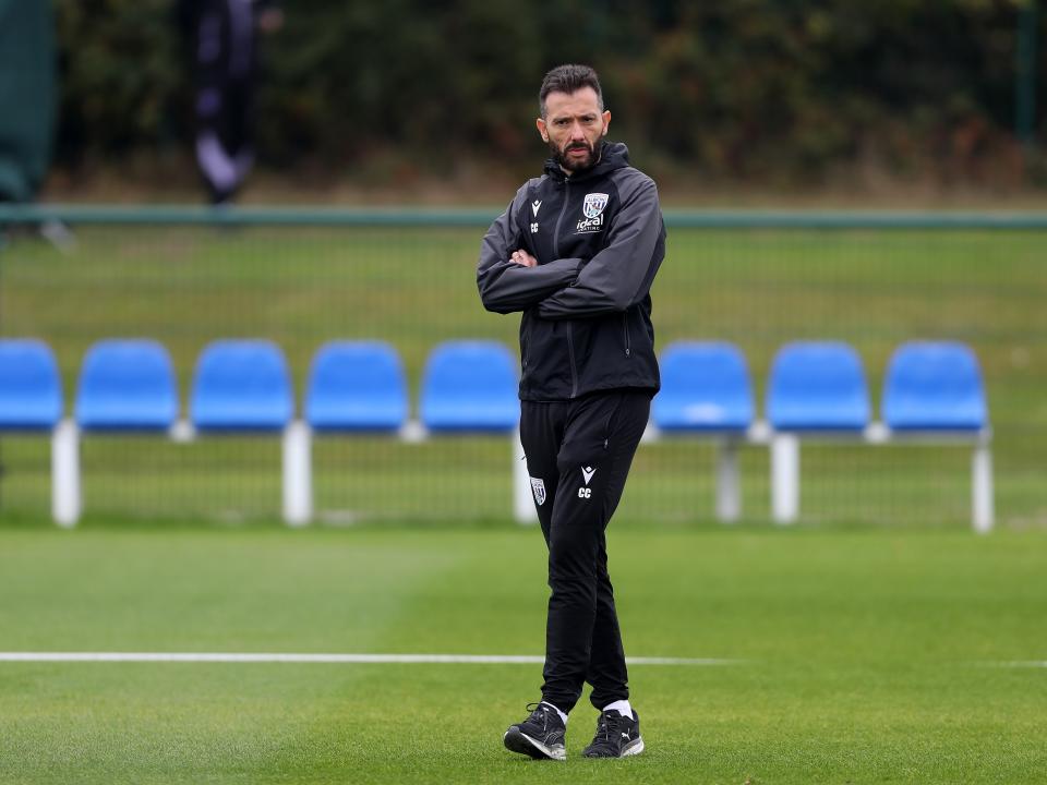 Carlos Corberán watching training with his arms folded 