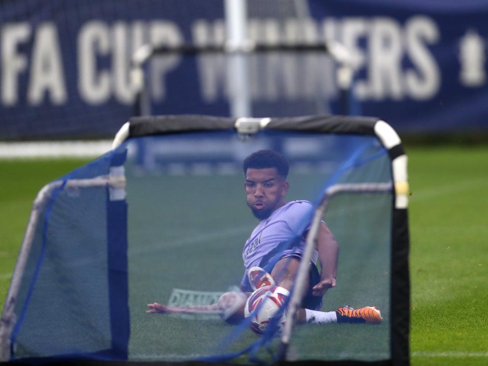 Mason Holgate sliding to reach a ball in front of a mini goal on the training pitch 
