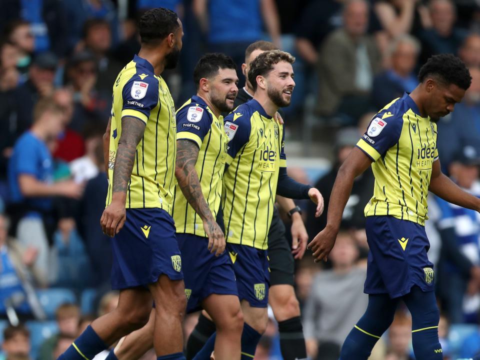 Albion in action against Portsmouth at Fratton Park, in yellow and blue away colours.