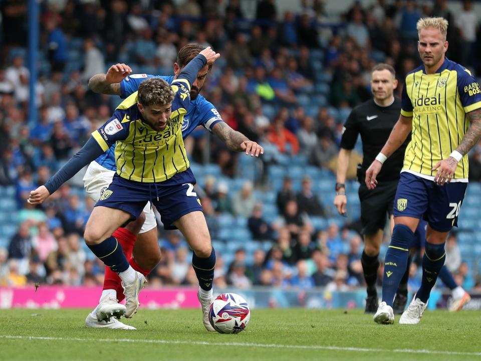 Albion in action against Portsmouth at Fratton Park, in yellow and blue away colours.