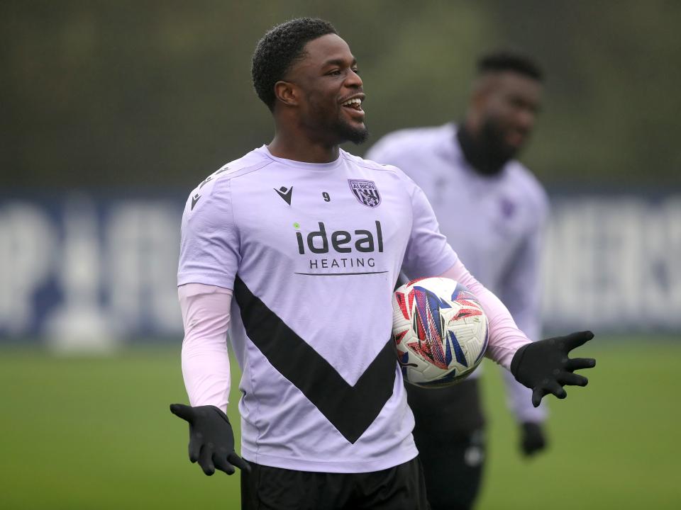 Josh Maja laughing during a training session holding his arms out with a ball 