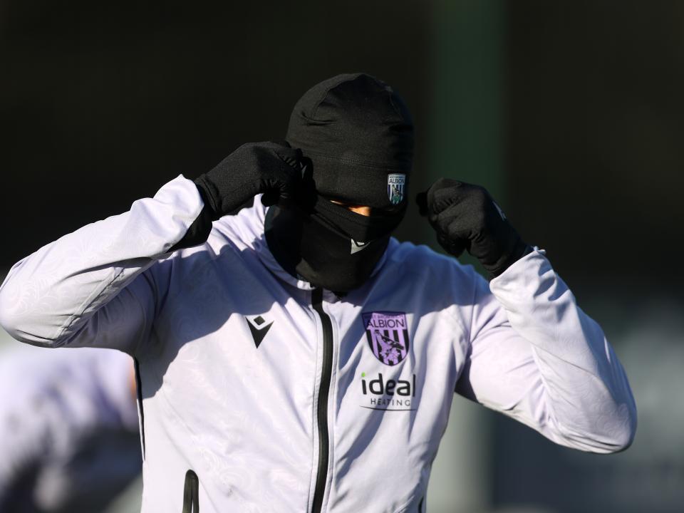 An Albion player wearing a hat and a snood during a training session
